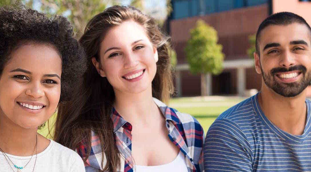 young students sitting together and smiling happily together